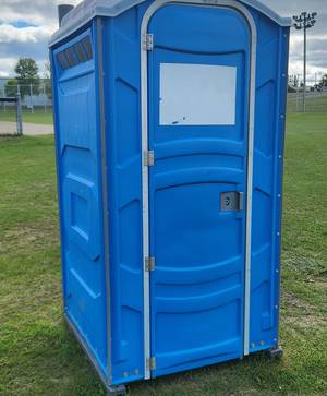 Portable toilet on the grass at a ball field